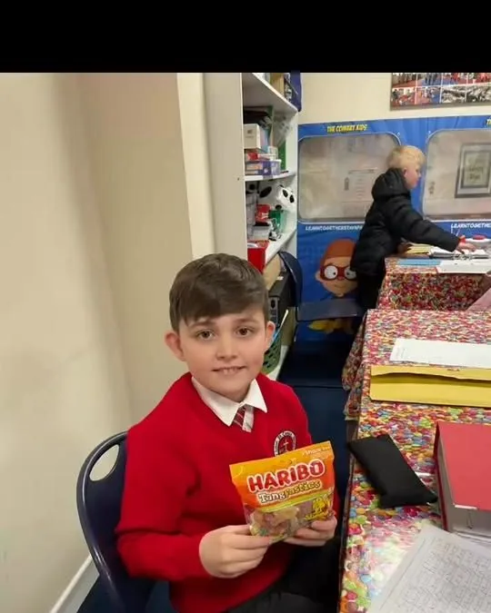 A pupil at his desk with the week's prize